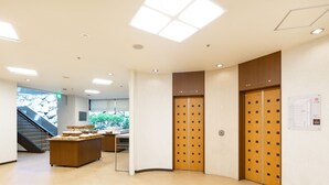 A modern lobby with a reception desk, double doors, and a staircase. - The OneFive Okayama (Okayama)