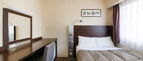 A hotel room with a bed, a desk, a chair, a mirror, a picture on the wall, and a window with curtains.
