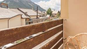 Un balcon donnant sur une montagne et une rangée de maisons.