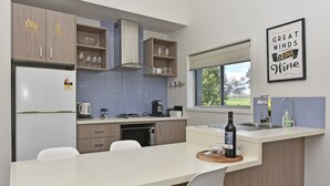 Eine moderne Küche mit Kochinsel, eingebauten Geräten und einem Fenster mit Blick.