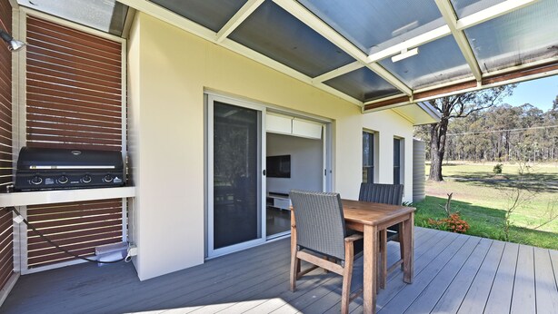 An outdoor patio with a grill, a table, and chairs. - Ironbark Hill Spa Bath Villa 4 - Novato (Pokolbin)