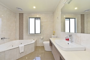 A modern bathroom with a bathtub, a toilet, and a sink.