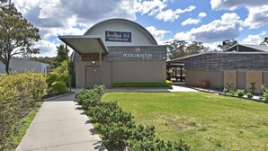 A building with a sign for IronBark Hill BREWHOUSE and Peter Drayton Wines. - Ironbark Hill Estate (Pokolbin)