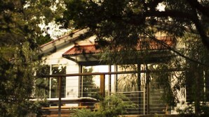 A modern house with large windows and a wooden deck.