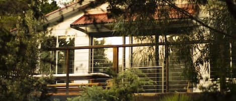 A modern house with large windows and a wooden deck.