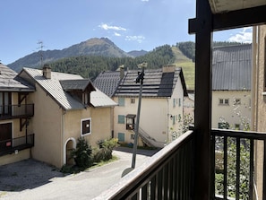A residential area with traditional architecture, a clear sky, and a mountain in the background.