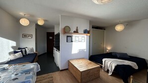 Una habitación acogedora y bien iluminada con una mesa de comedor de madera, un sofá y un banco de madera.