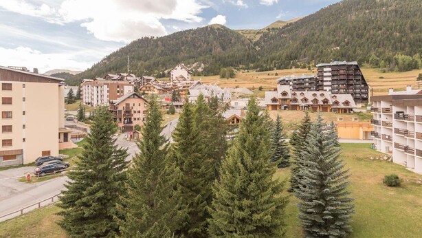 Zona residencial con edificios de varios pisos, incluyendo una estructura moderna distintiva con techo inclinado.