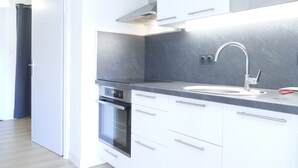A modern kitchen with white cabinets, a stainless steel sink, and a built-in oven. - Renovated studio 4 pers with south balcony Les 2 Alpes (Les Deux Alpes)