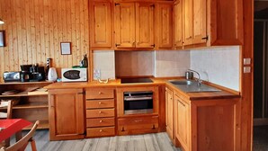 A wooden-paneled kitchen with a microwave, coffee maker, and a sink.