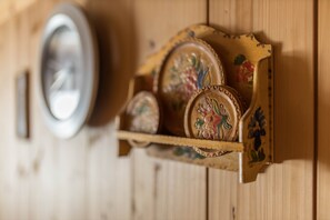 A wooden wall with a shelf holding decorative items.