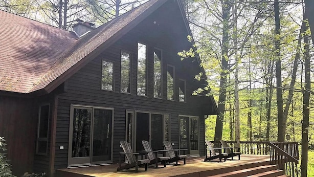 A cabin with a deck, large windows, and a staircase leading to the entrance. - Adirondack “River Rapture"- Lake George/Mount Gore (Warrensburg)
