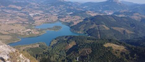 A mountainous landscape with a lake and forested areas.