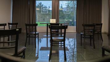 A conference room with a glass table, six chairs, and a laptop on the table.