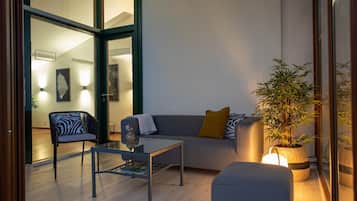 Una sala de estar moderna con un sofá, un sillón, una mesa de centro y una planta en maceta.