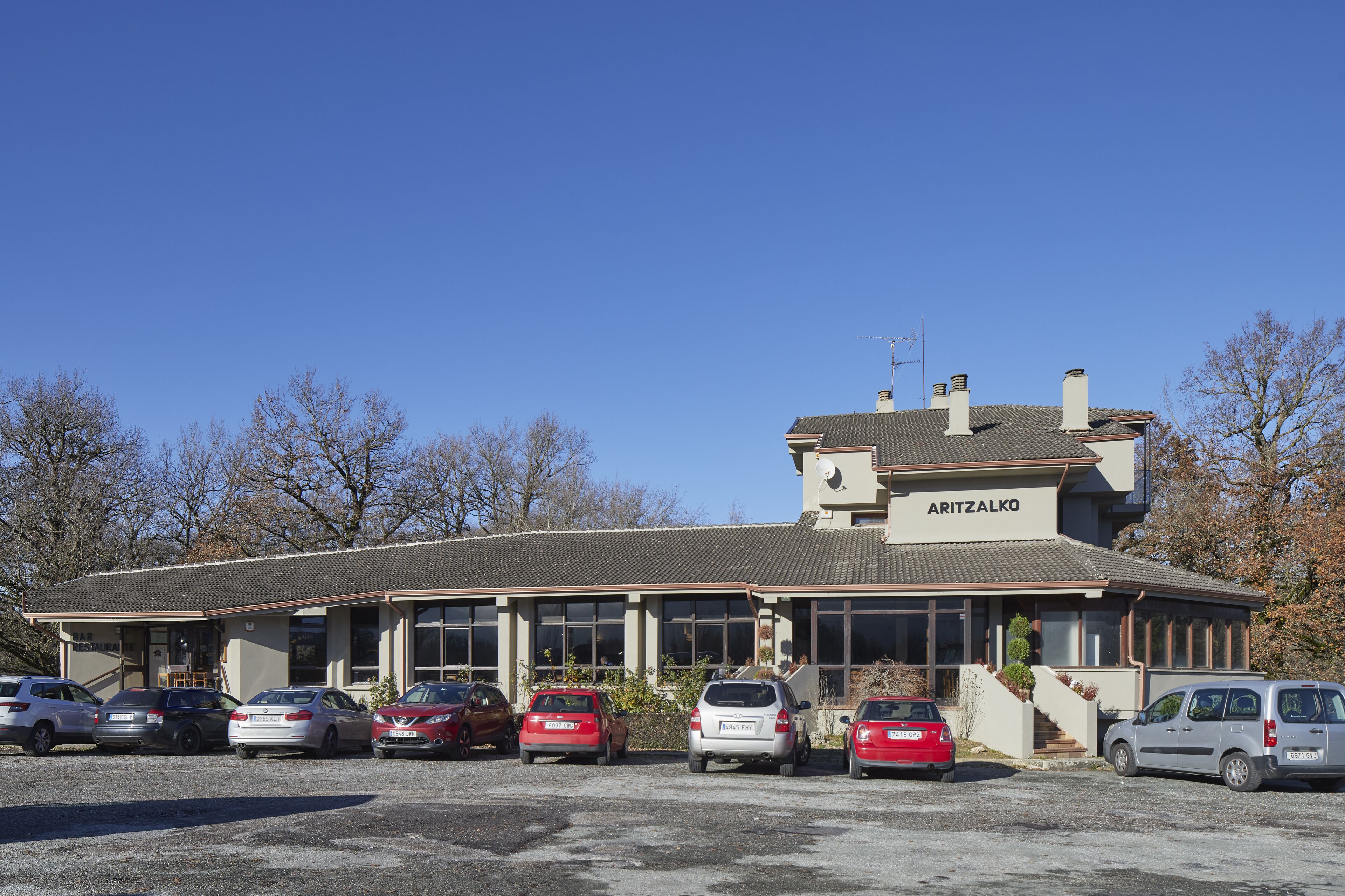 Un bâtiment sur lequel on peut lire l’inscription « ARITZALKO », et un parking où sont garées plusieurs voitures.
