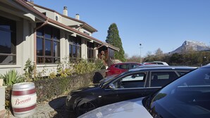 A building with a large barrel labeled "Beronia" in front, parked cars, and a mountain in the background. - Aritzalko (Etxarri-Aranatz)