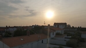 Asuinalue, jossa on taloja ja parkkeerattuja autoja auringonlaskun aikaan.