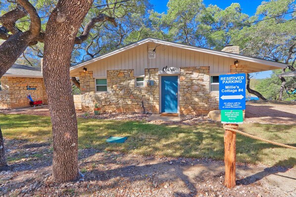 Edificio de piedra con una puerta azul identificada como 'Clara's Cottage #4'.