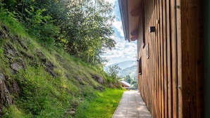 A wooden building with a paved walkway leading to a mountain view. - Woody 21 - the Tiger Woody (St. Georgen am Kreischberg)