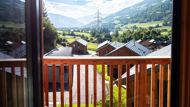 A view from a wooden balcony overlooking a rural landscape with houses and mountains. - Woody 21 - the Tiger Woody (St. Georgen am Kreischberg)