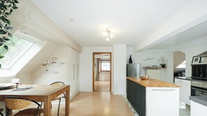 Una cocina moderna con una mesa de comedor de madera, sillas y un horno empotrado.