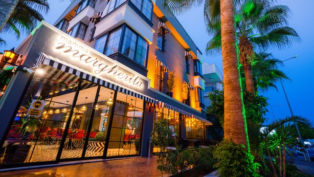 A modern building with a restaurant named "mamma margherita" on the ground floor.