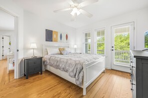 A bedroom with a bed, nightstands, a ceiling fan, and a window with blinds.