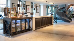 Eine moderne Hotellobby mit einer Rezeption, einer Wendeltreppe und einer gekühlten Auslage.