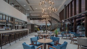 Ein modernes Interieur mit Barbereich, Sitzgelegenheiten und einer Treppe.