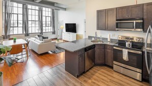Una cocina moderna con armarios oscuros, electrodomésticos de acero inoxidable y una isla central.