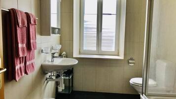 A bathroom with a sink, mirror, and window.