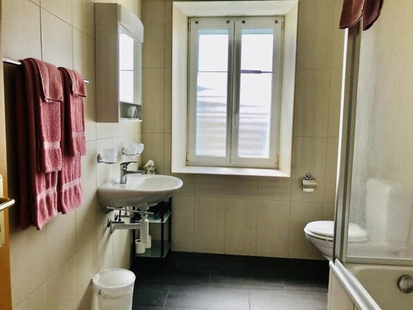 Un baño con lavamanos, espejo y ventana.