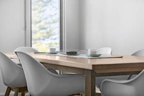 A dining table with chairs, a white bowl, and a cup.
