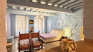 A bedroom with a bed, a wooden table, and a vase.