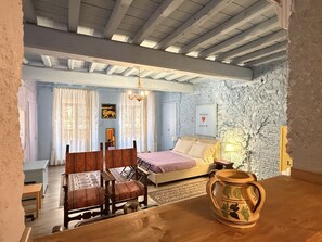 A bedroom with a bed, a wooden table, and a vase.