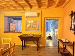 A room with a wooden ceiling, a table with candles, a mirror, and a clock on the wall.