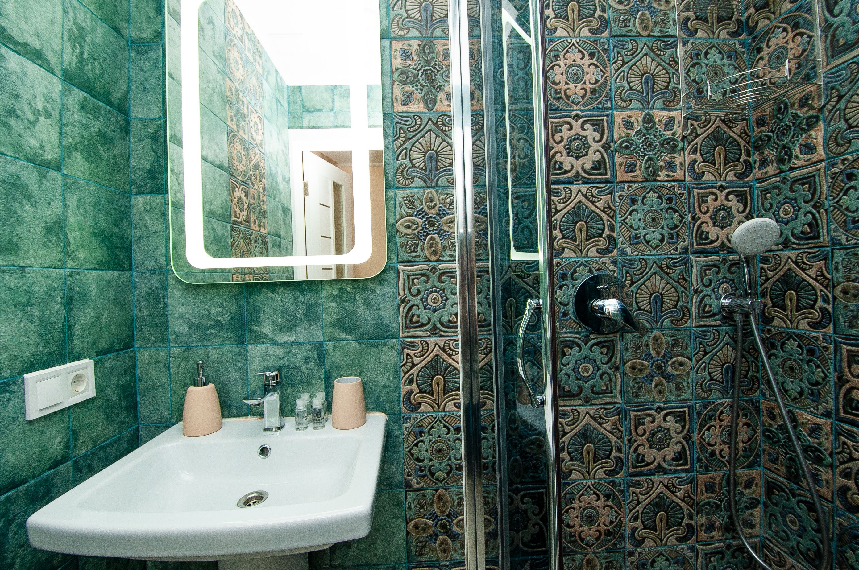 Un baño con lavamanos, espejo y cabina de ducha.