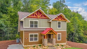 A two-story house with a stone foundation, a red roof, and a wooden exterior. - Tennessee Dream (Gatlinburg)
