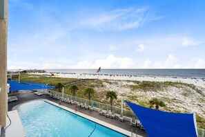 A pool area with a view of the beach and ocean.