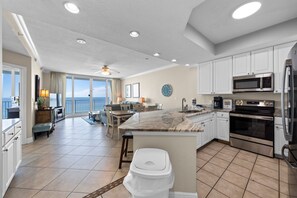 A spacious kitchen with a large island, white cabinetry, and modern appliances.