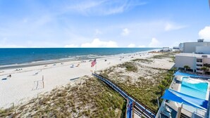 Una playa con una bandera, una piscina y un edificio.