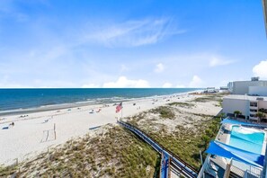 Una spiaggia con una bandiera, una piscina e un edificio.