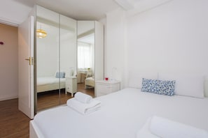 Une chambre moderne avec un grand lit, une table de chevet, un bureau et une armoire.