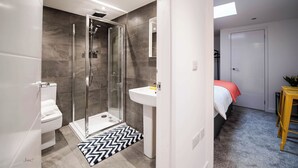 A modern bathroom with a glass-enclosed shower, a white sink, and a visible toilet. - Windmill House Apartment 2 (Lytham Saint Annes)