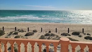 Ein Strand mit sandigem Ufer und blauem Himmel.
