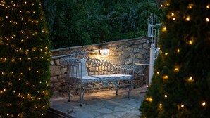 A stone bench with a metal frame, a wall-mounted light, and a staircase leading up.