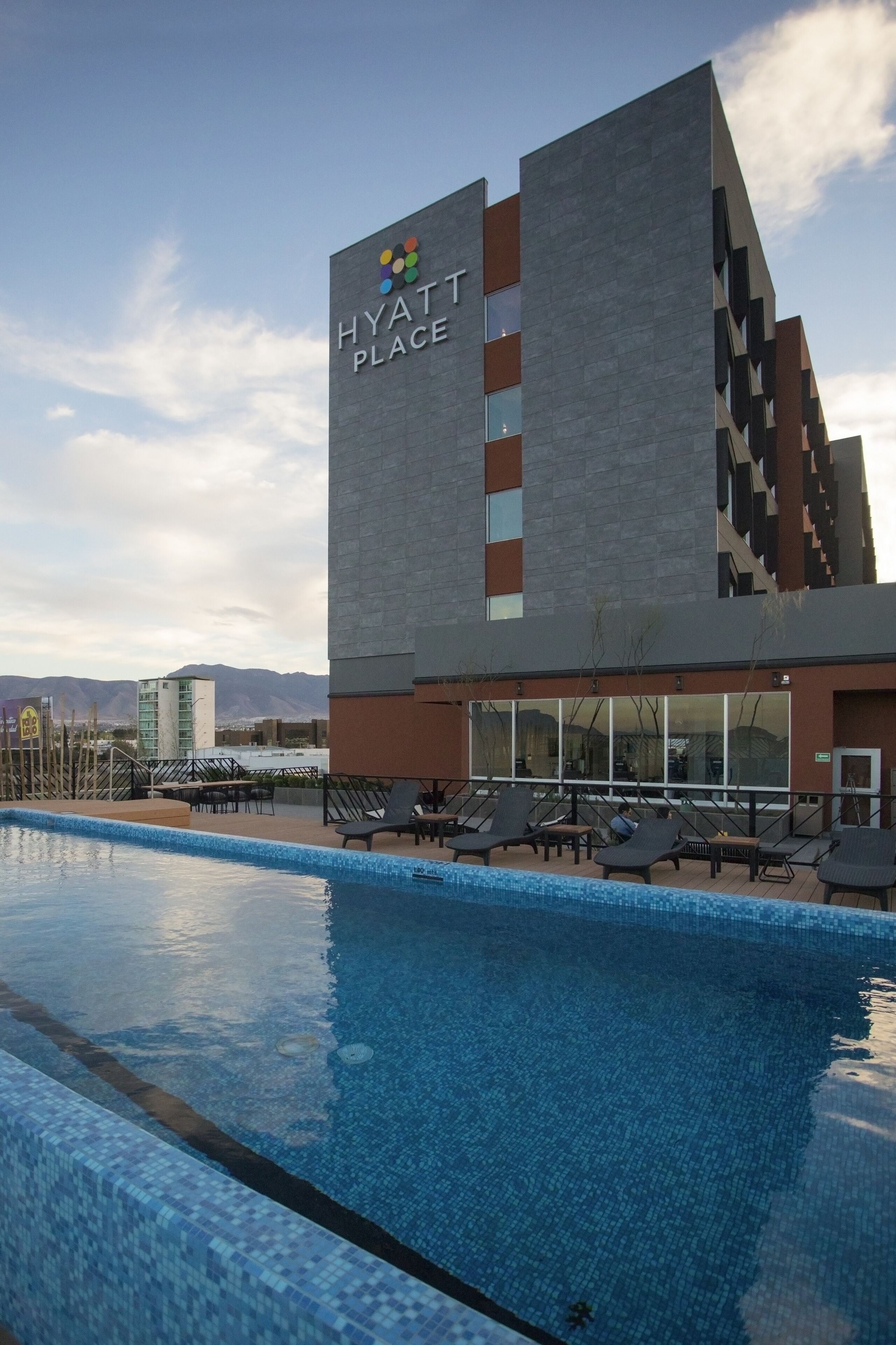 Una piscina al aire libre, sillones reclinables de piscina