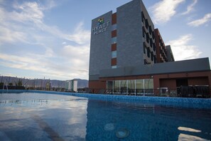 A Hyatt Place hotel with a modern design, a swimming pool, and a view of mountains in the background. - Hyatt Place Saltillo (Saltillo)