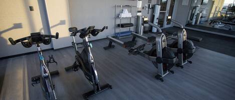 A gym with stationary bikes, treadmills, and weight machines.